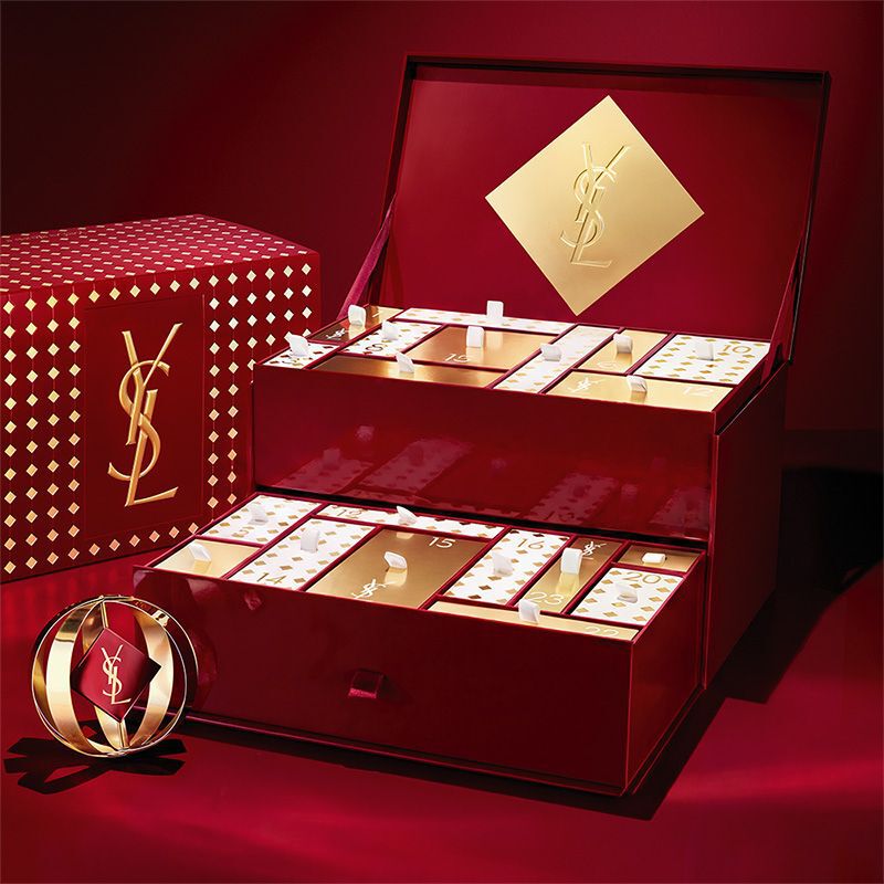 YSL beauty advent calendar with cosmetics and fragrances in a red-and-gold display.