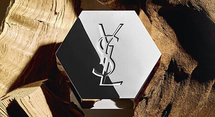 An elegant hexagonal bottle featuring a logo, placed against a background of wooden textures.