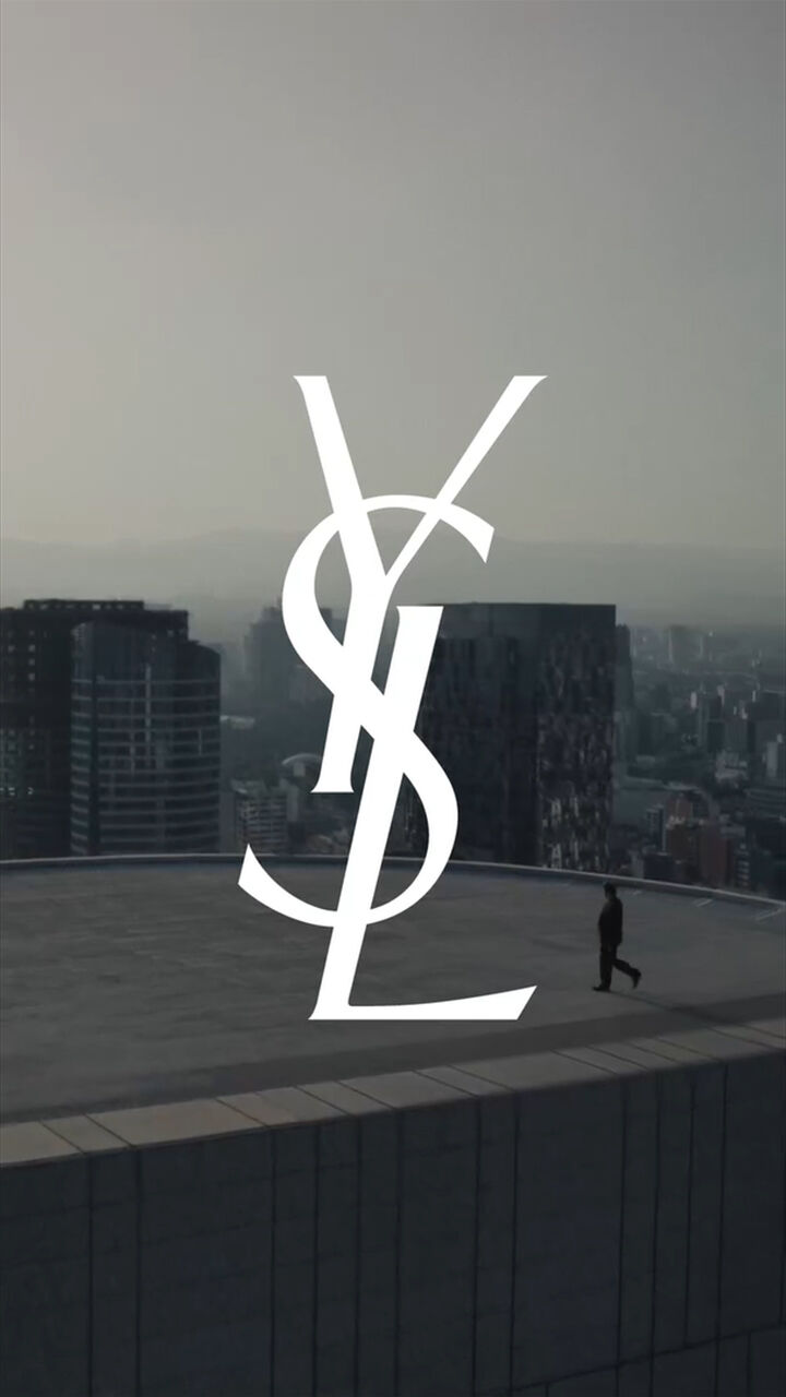 YSL logo over rooftop skyline at sunset