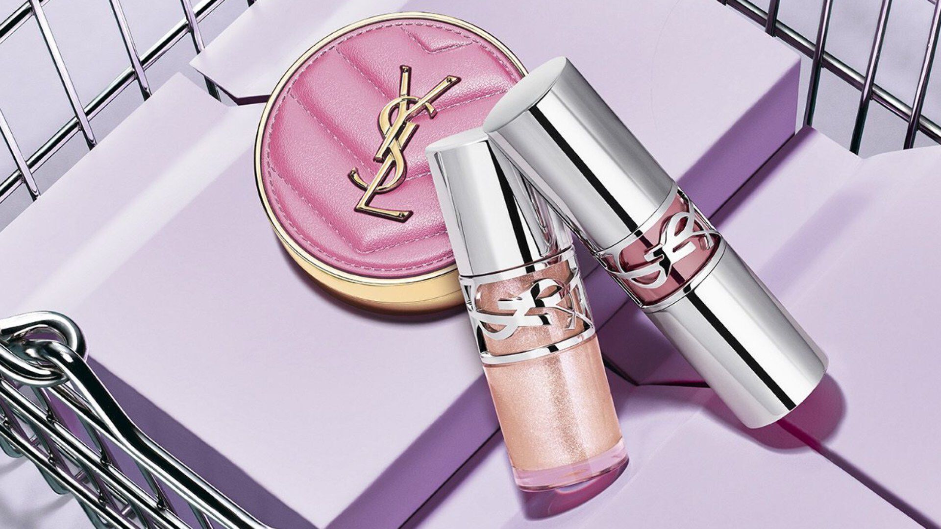 YSL pink compact and lipsticks in a silver shopping basket.