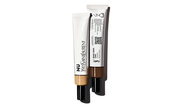 Two tubes of makeup from Yves Saint Laurent, one in light beige and the other in dark brown, displayed against a white background.