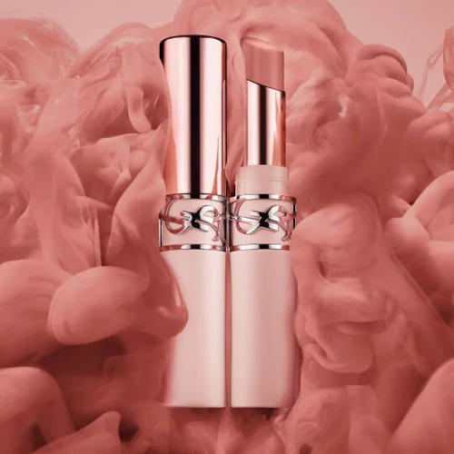 Two rose-gold lipstick tubes on a soft pink smoky background.