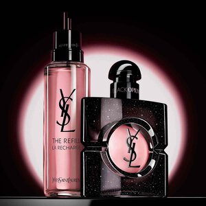 A hand holding a gold refill bottle against a neutral background. To the left, white brush-style text reads "Join the REFILL Movement," and to the right, a classic YSL Libre glass fragrance bottle with its signature gold logo is displayed.