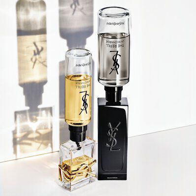 Two Yves Saint Laurent perfume bottles (one light, one dark) with their refillable cartridges shown.