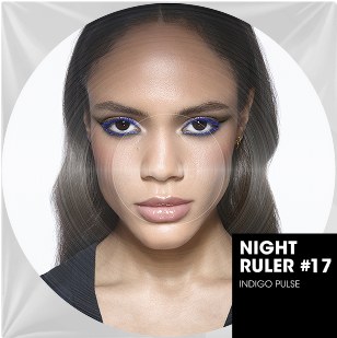 A close-up color portrait of a woman with long, straight brown hair and a fair complexion. Her eyes are intensely made up with vibrant electric blue eyeliner and bronze eyeshadow. Her lips are natural and glossy. In the bottom right of the circular image, a black rectangular overlay indicates "NIGHT RULER #17" and "INDIGO PULSE," suggesting an energetic and bold collection or ambiance, like a music track title.