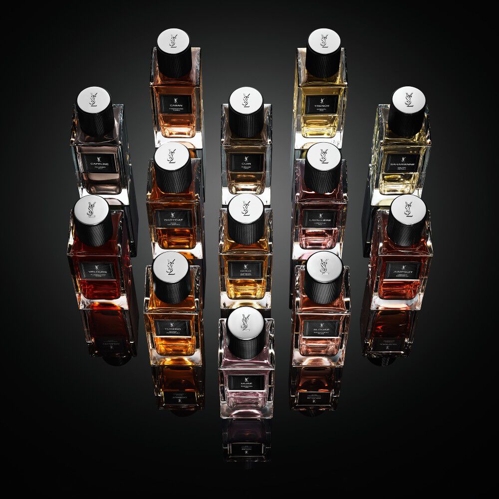 A collection of Yves Saint Laurent "Le Vestiaire des Parfums" fragrance bottles arranged in a diamond shape on a reflective black surface.