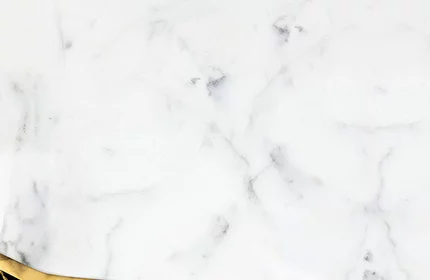 Two elegant perfume bottles are positioned on a marble surface with a black and gold accent. The background features a sleek white marble texture.