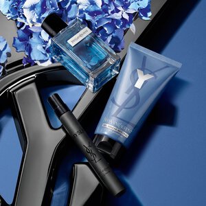 Blue YSL gift box surrounded by blue hydrangeas on a blue background.