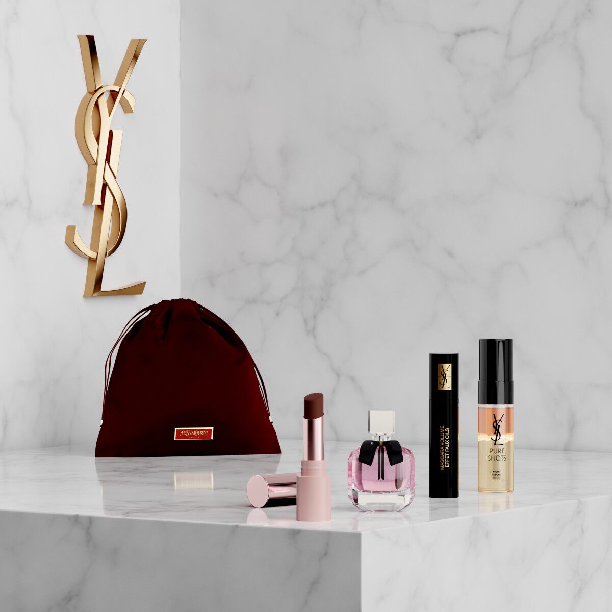 YSL Beauty makeup set with pink pouch, lipstick, eyeliner, mascara and mini fragrance on a marble shelf.