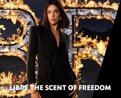 A woman in a sleek black suit stands next to the text "LIBRE THE SCENT OF FREEDOM," with flames in the background.