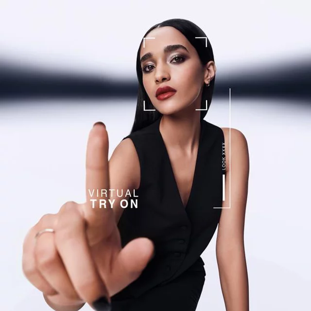 A woman points forward, interacting with a virtual try-on screen. A graphic overlay shows "VIRTUAL TRY ON" and "LOOK XXXX" around her face. She wears a black vest.