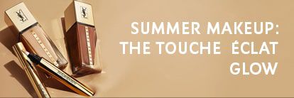 Image features two bottles of YSL makeup foundation and a Touche Eclat Glow pen on a warm, neutral background. The text reads "SUMMER MAKEUP: THE TOUCHE ECLAT GLOW."