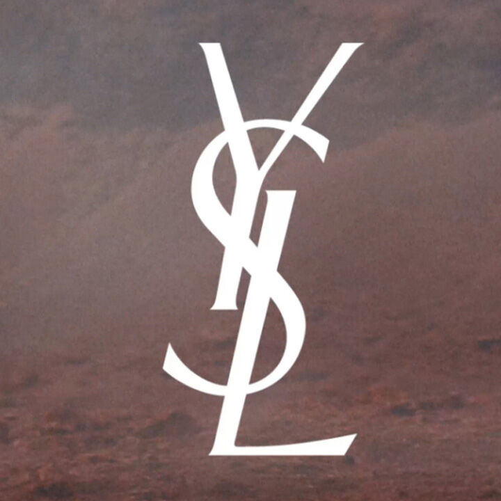 The image features the stylized logo of Yves Saint Laurent (YSL) in white against a textured background.
