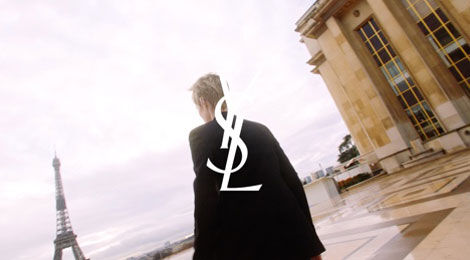 A couple leans in close, sharing a tender moment as they almost kiss, with a warm sunset in the background. The scene is softly illuminated and conveys an intimate atmosphere.