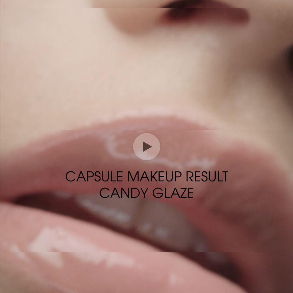 Close-up of glossy, soft pink lips with a caption that reads "CAPSULE MAKEUP RESULT CANDY GLAZE" along with a play button icon.