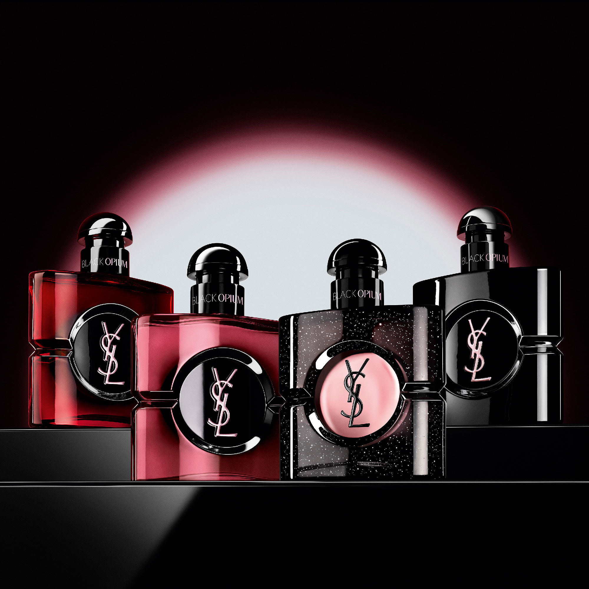 Four different Black Opium perfume bottles displayed
                        in a row on a dark, reflective surface.