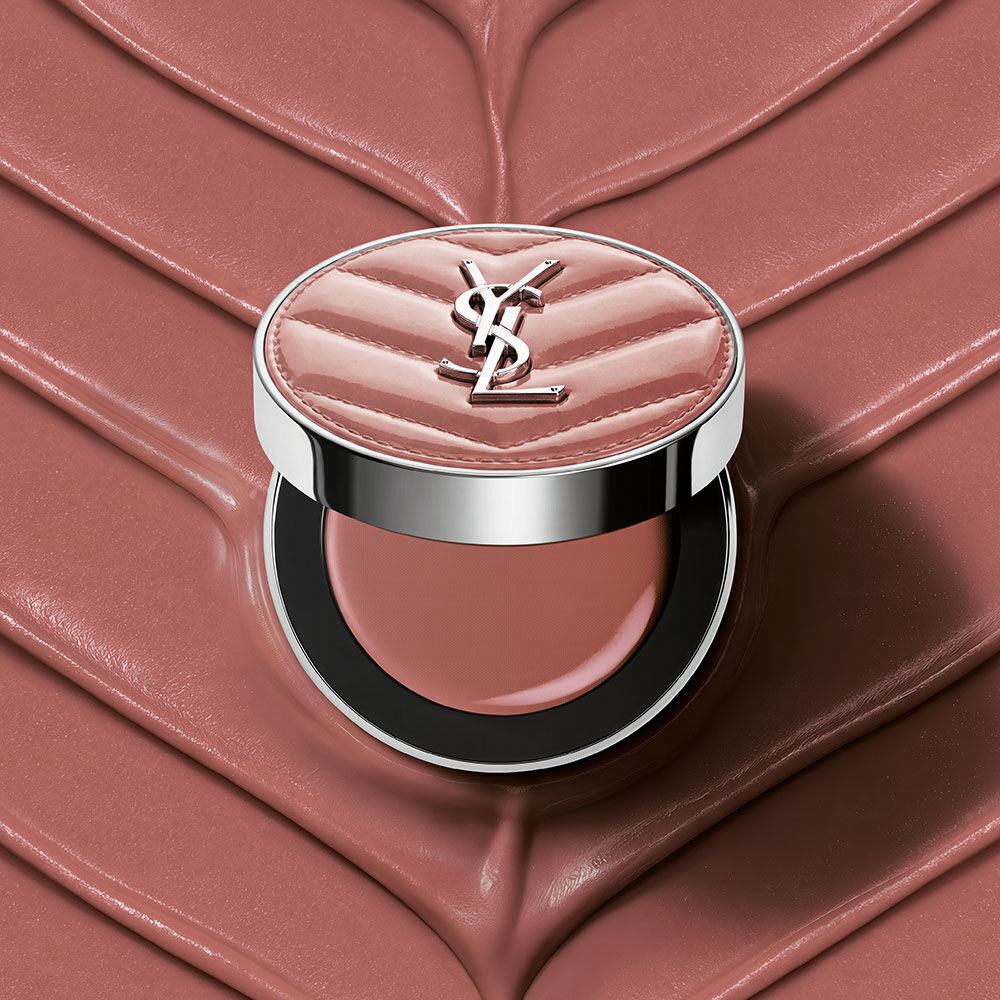 An open YSL Make Me Blush Lifted Glow Cream Blush compact in shade #44 Nude Lavalliere on a matching pink textured cream background.