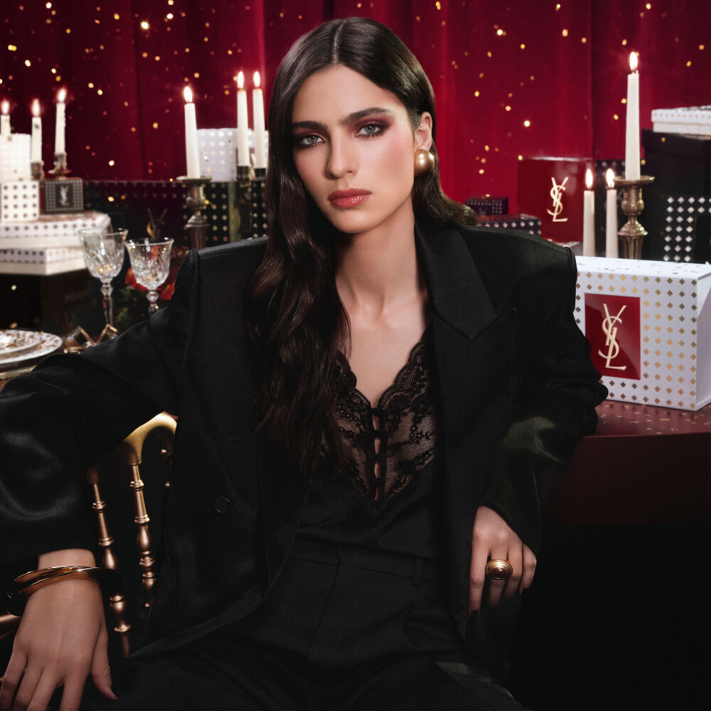  ALT & SEO HOLIDAY  100% B7  Model wearing a black suit and glam look, seated in a festive candlelit setting with YSL gift boxes.      	 Model wearing a black suit and glam look, seated in a festive candlelit setting with YSL gift boxes.  Model wearing a black suit and glam look, seated in a festive candlelit setting with YSL gift boxes. B7Banner hidden
