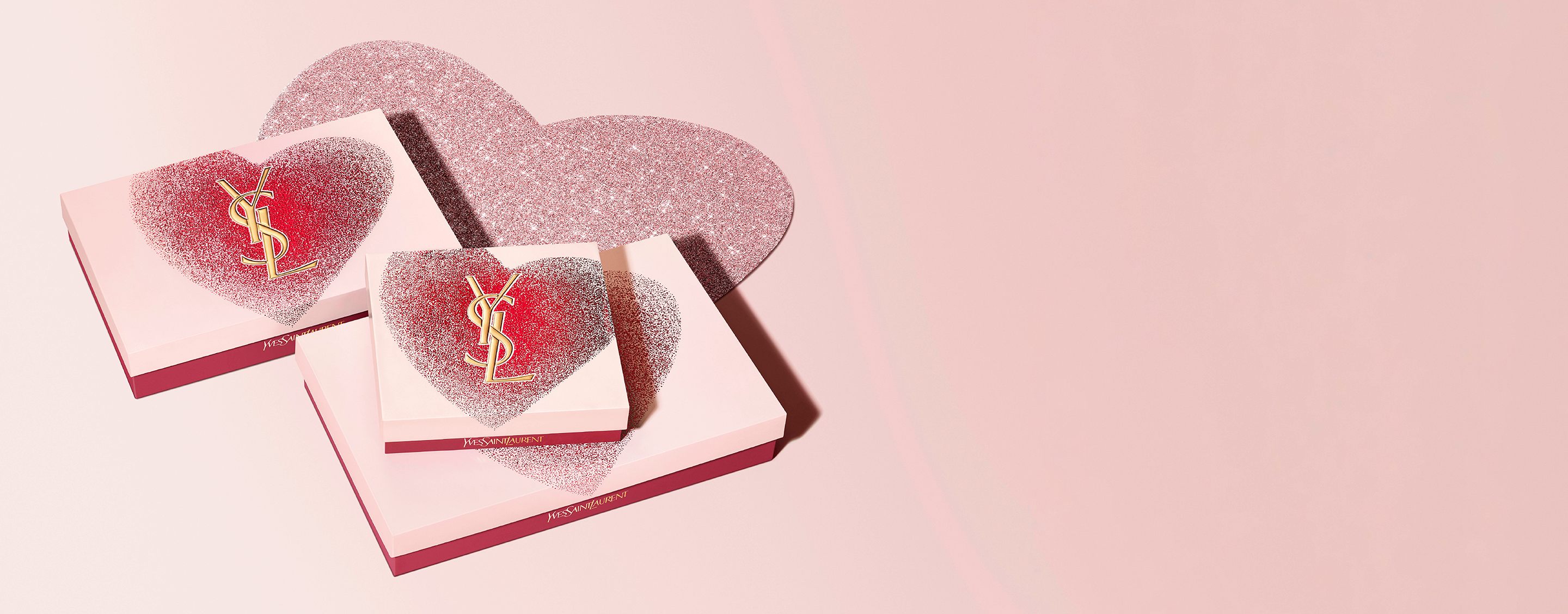 YSL Beauty Valentine's day gift sets in heart-shaped
boxes with gold YSL logo, featuring a glittery red and
pink design.