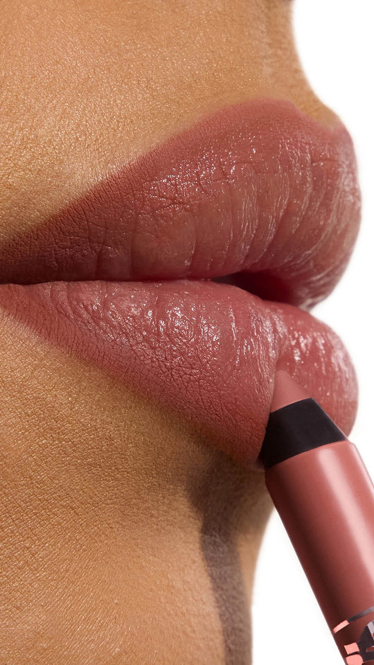 Vertical close-up of rosy-brown matte lips with a matching lip pencil being applied.