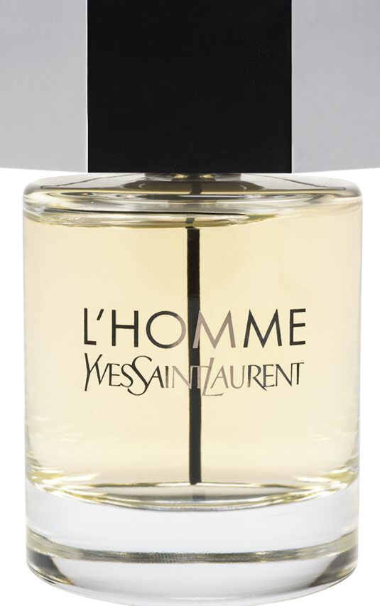A bottle of Yves Saint Laurent L'Homme fragrance with a clear glass body, light amber liquid, and a large silver hexagonal cap.