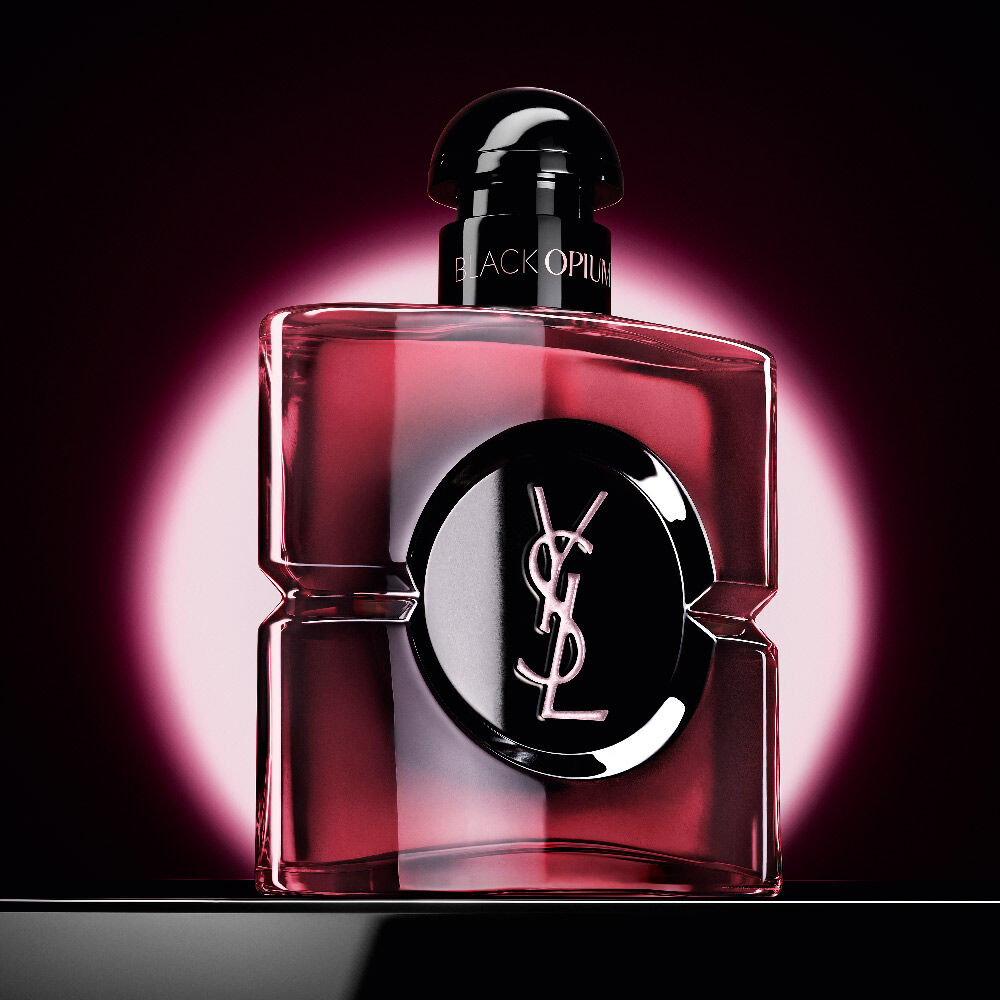 Black
                Opium Eau de Parfum Pink Glaze bottle highlighted by a pink circular glow on a dark
                background.
