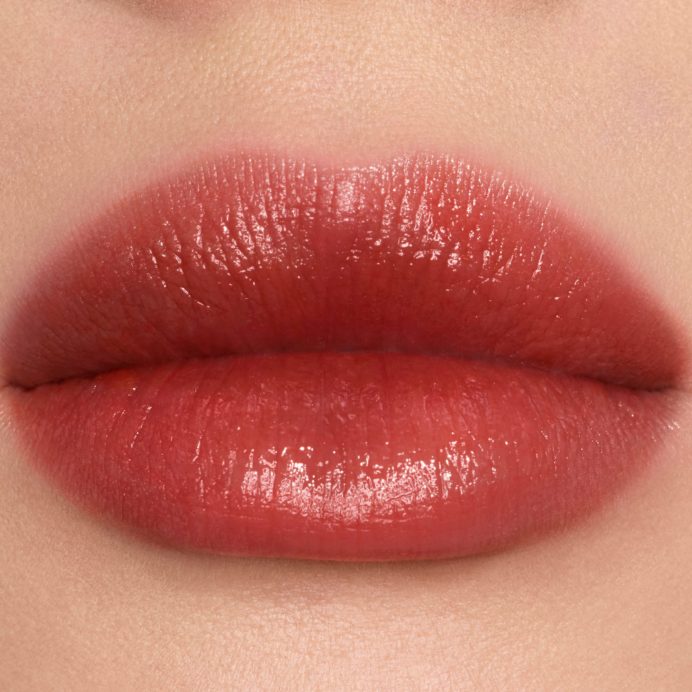 Close-up lip swatches of YSL vinyl-shine color stains in shades #446 Spiced Secret.