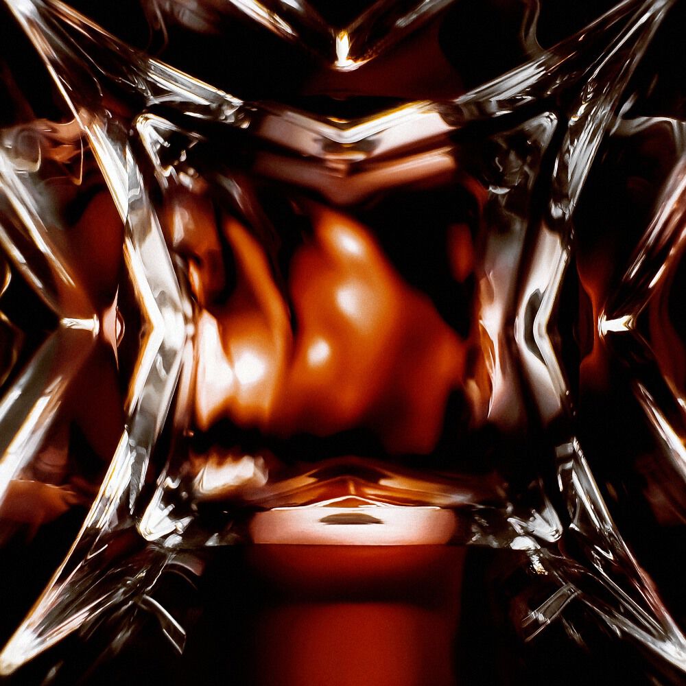 Macro shot of a luxury perfume bottle featuring a glass chevron pattern with glowing amber liquid and reflections.