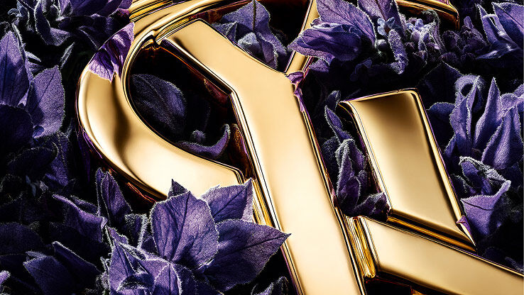 Rich purple lavender blooms highlighting the sharp, golden edges of the YSL logo.