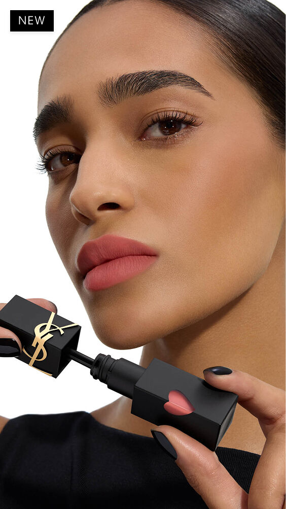 Deep-medium skin tone model with a soft-focus matte lip look holding the YSL THE INKS BLUR lip stain applicator next to her chin.