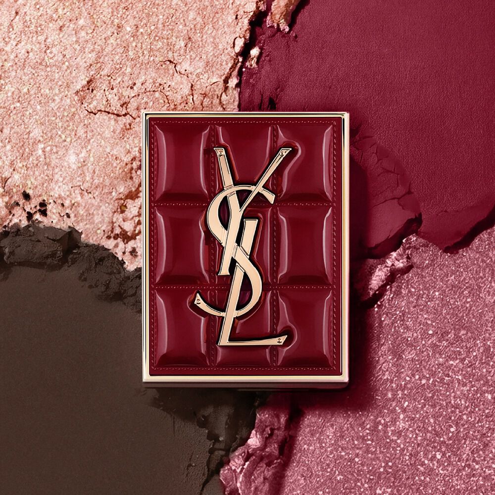 YSL Couture Mini Clutch palette set against a textured background of shimmering eyeshadow powders of #1982 Burgundy Millesime.