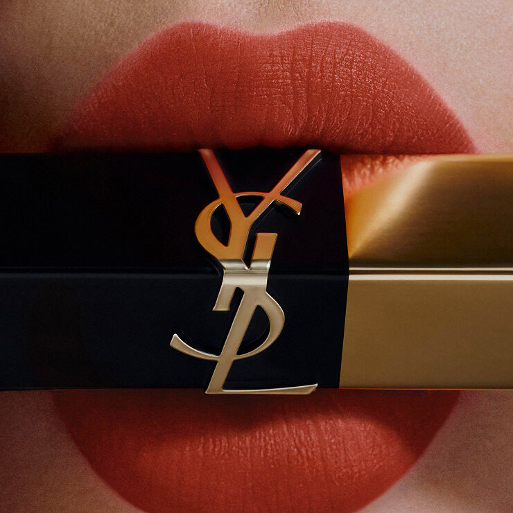 Close-up of coral lips applying a square lipstick bullet.